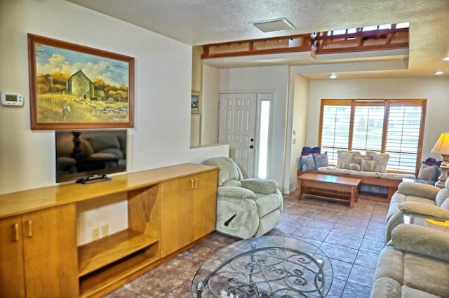 tiled living room featuring a textured ceiling