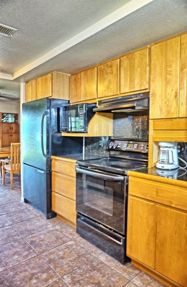 kitchen with a textured ceiling, dark tile patterned floors, black range with electric stovetop, and decorative backsplash