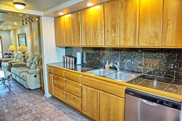 kitchen featuring dark tile patterned floors, dishwasher, sink, and decorative backsplash