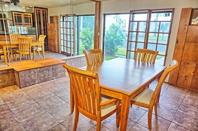 dining space featuring dark tile patterned flooring and ceiling fan