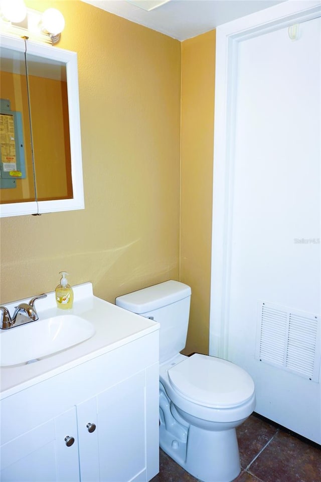 bathroom with tile patterned flooring, vanity, and toilet