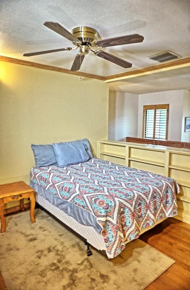 bedroom featuring a textured ceiling, hardwood / wood-style flooring, and ceiling fan