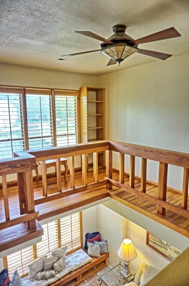 interior space featuring a textured ceiling, ceiling fan, and hardwood / wood-style floors