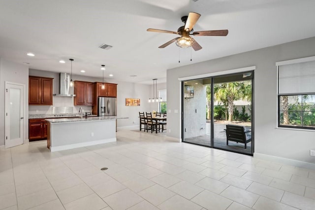 kitchen with visible vents, pendant lighting, recessed lighting, stainless steel fridge with ice dispenser, and wall chimney range hood