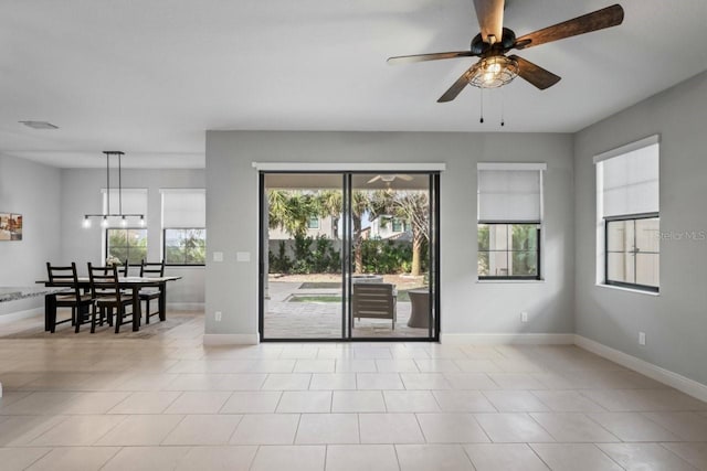 spare room featuring a ceiling fan and baseboards