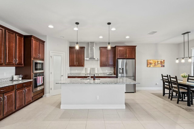 kitchen featuring visible vents, wall chimney range hood, recessed lighting, stainless steel appliances, and a kitchen island with sink