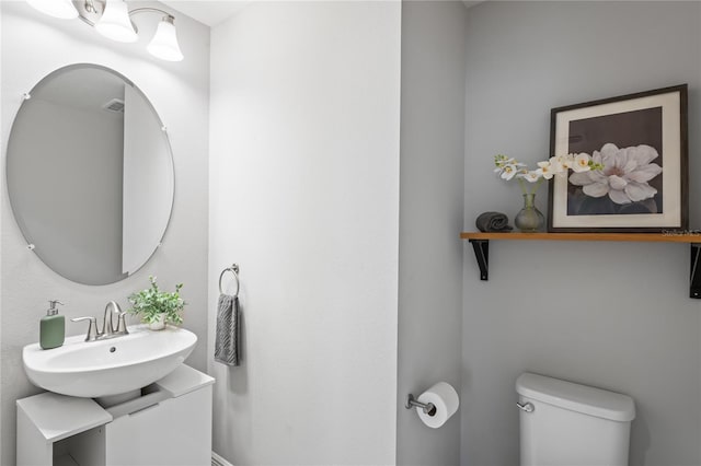 bathroom featuring a sink, visible vents, and toilet