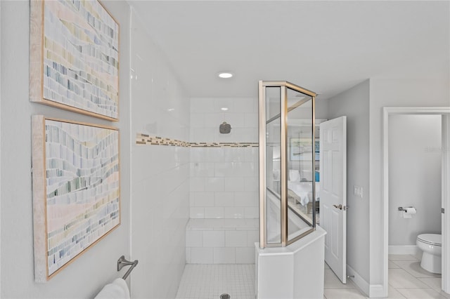 full bath featuring tile patterned floors, a shower stall, toilet, and baseboards