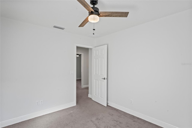 spare room with visible vents, carpet floors, baseboards, and a ceiling fan