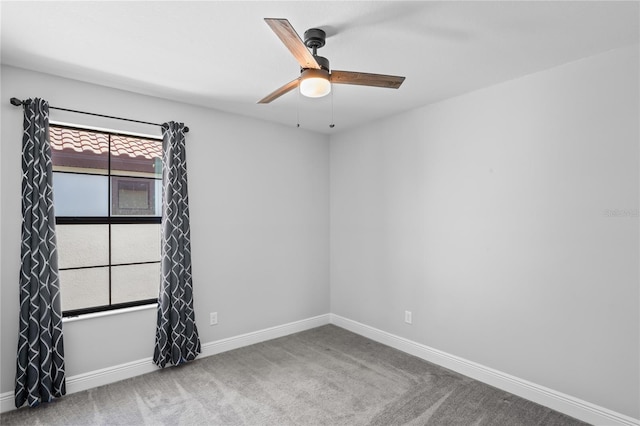 unfurnished room with carpet flooring, a ceiling fan, and baseboards