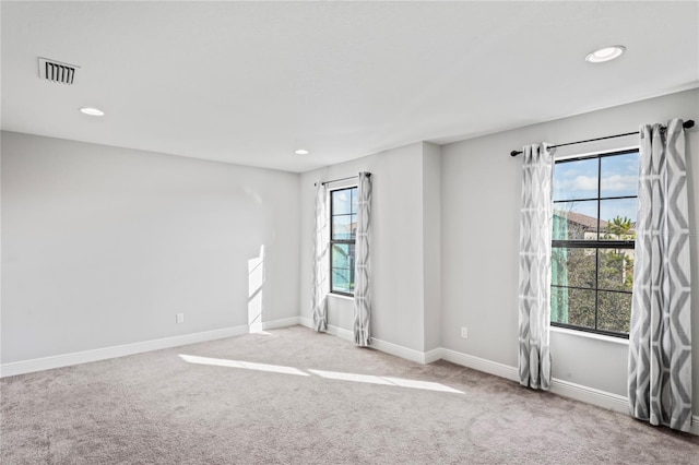 carpeted spare room with recessed lighting, baseboards, and visible vents