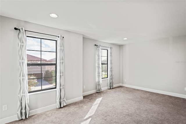 empty room featuring a wealth of natural light, baseboards, carpet, and recessed lighting