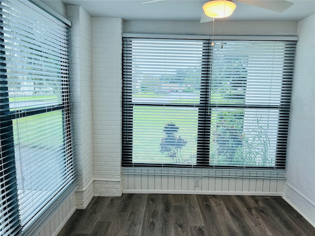 empty room featuring dark wood-type flooring, ceiling fan, and plenty of natural light