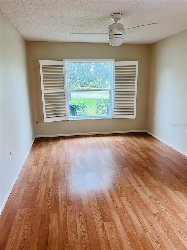 unfurnished room featuring a textured ceiling, ceiling fan, and light wood-type flooring