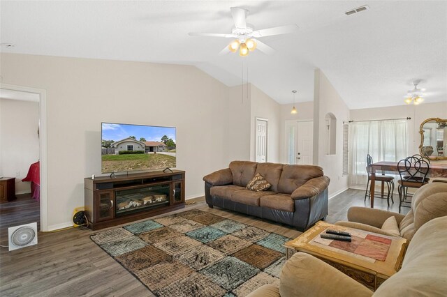 living room with dark hardwood / wood-style flooring, ceiling fan, and vaulted ceiling