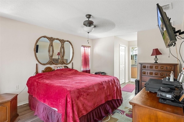 bedroom with ceiling fan, a closet, a textured ceiling, and wood-type flooring