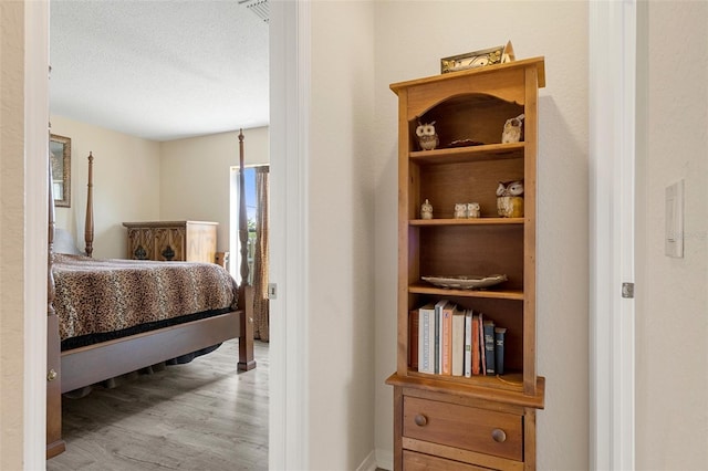 bedroom with a textured ceiling and wood-type flooring