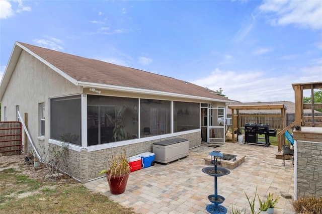 rear view of property with a sunroom and a patio area