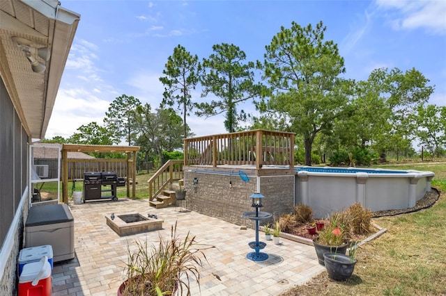 view of patio / terrace with an outdoor fire pit and a swimming pool side deck