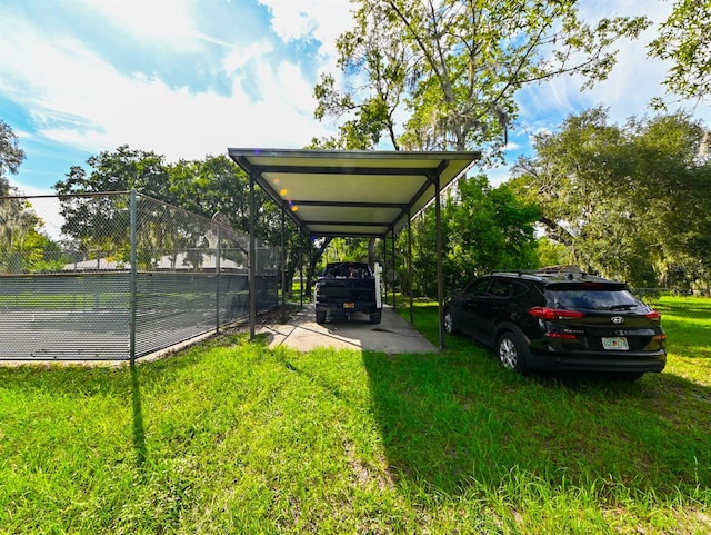 view of vehicle parking with a yard and a carport