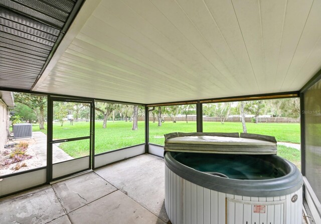 unfurnished sunroom with a hot tub