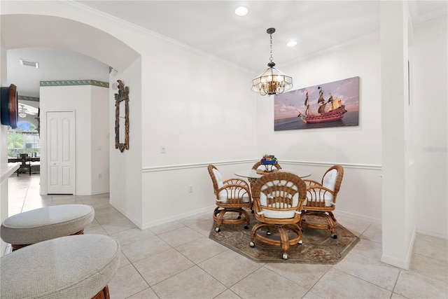 dining area with crown molding, an inviting chandelier, and light tile patterned flooring