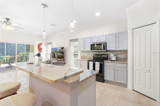 kitchen with plenty of natural light, electric range, sink, and a kitchen island with sink