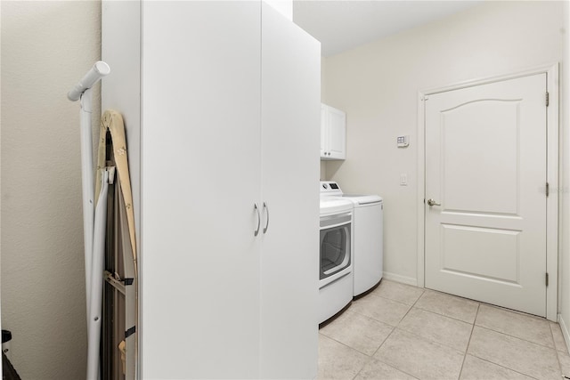 washroom with cabinets, independent washer and dryer, and light tile patterned flooring