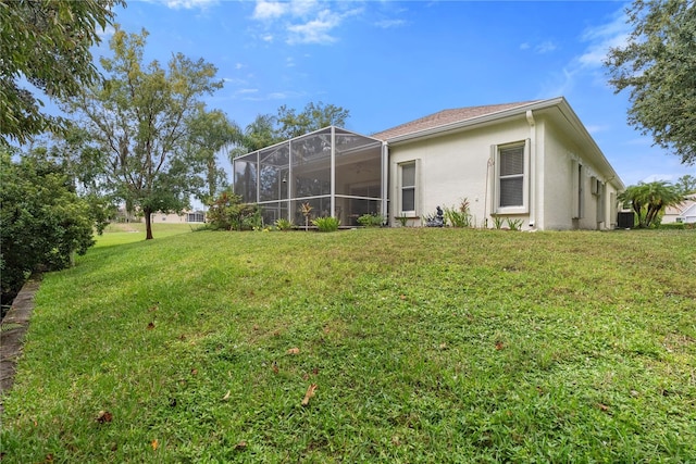 back of house featuring a lawn and glass enclosure