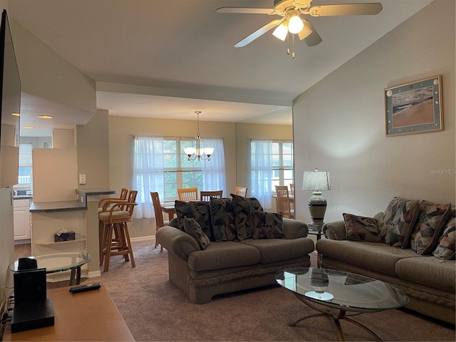 living room featuring lofted ceiling, ceiling fan with notable chandelier, and carpet floors