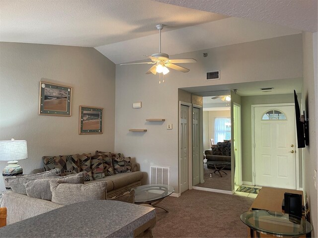 living room featuring a textured ceiling, lofted ceiling, ceiling fan, and carpet floors