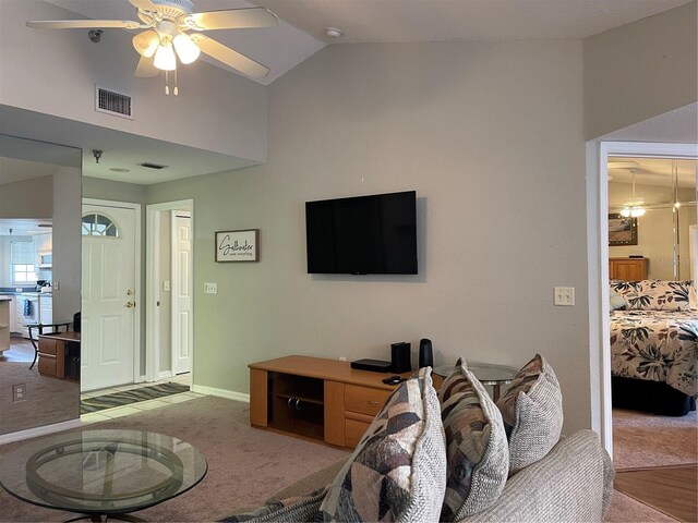 carpeted living room featuring vaulted ceiling and ceiling fan