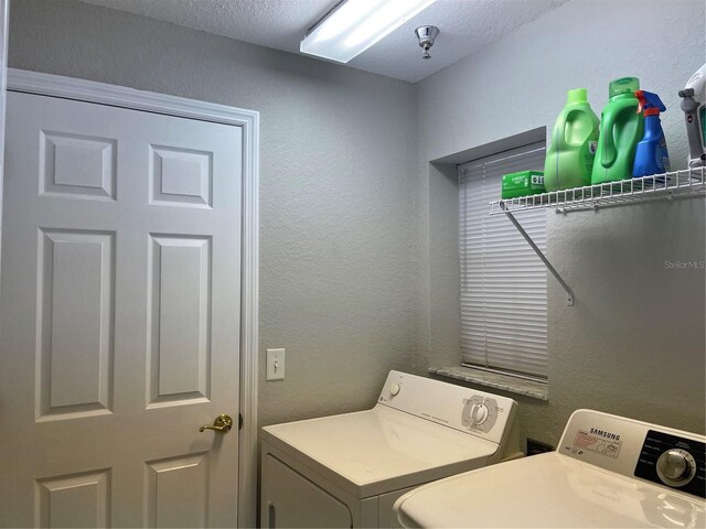 clothes washing area featuring a textured ceiling and separate washer and dryer