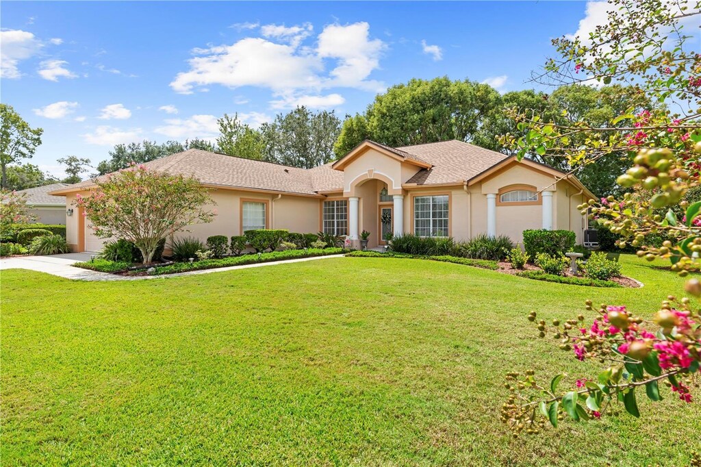 view of front of home with a garage and a front lawn