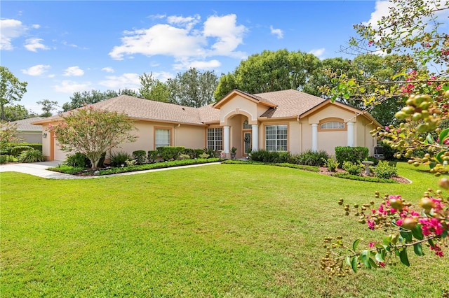 view of front of home with a garage and a front lawn