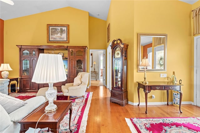 living room featuring light wood-type flooring and high vaulted ceiling