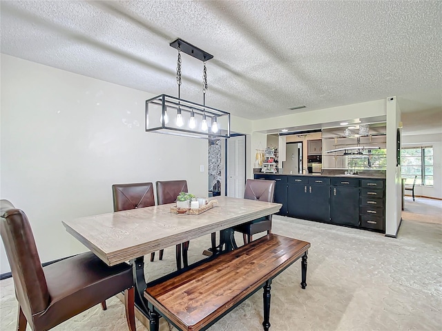 dining space featuring a textured ceiling and sink