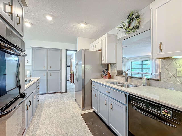 kitchen featuring a textured ceiling, sink, backsplash, and black appliances