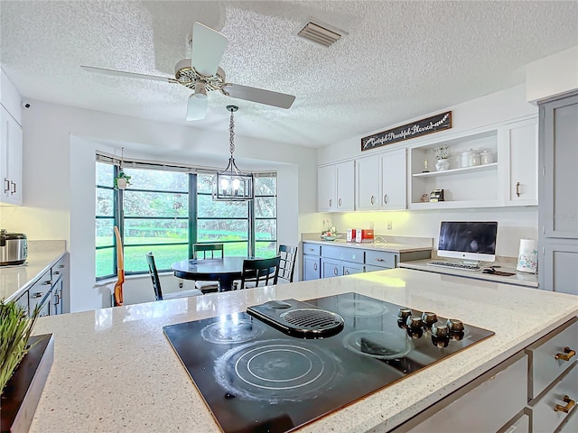 kitchen with ceiling fan with notable chandelier, decorative light fixtures, white cabinetry, black electric stovetop, and light stone counters