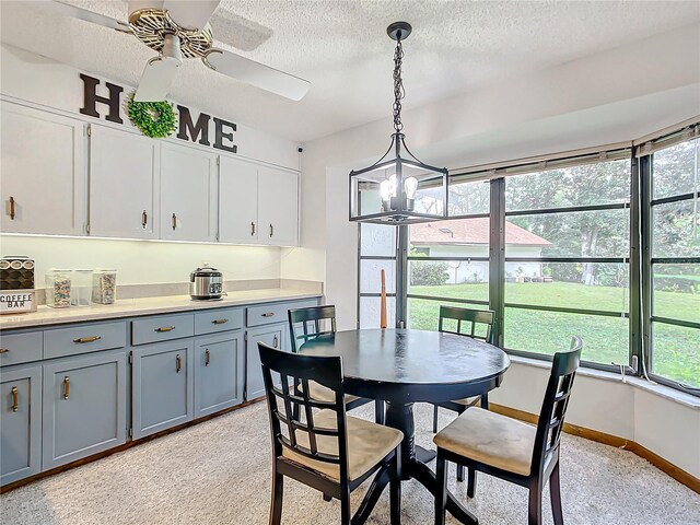 dining room featuring ceiling fan with notable chandelier and a textured ceiling