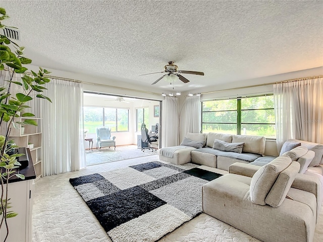 living room featuring a textured ceiling, ceiling fan, and plenty of natural light