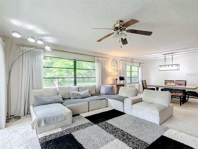 living room featuring ceiling fan and a textured ceiling