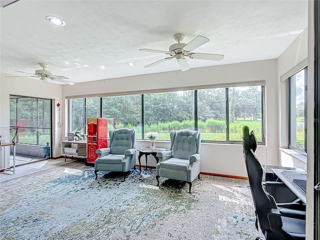 sunroom featuring ceiling fan and plenty of natural light