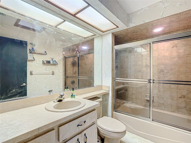 full bathroom featuring enclosed tub / shower combo, vanity, and toilet