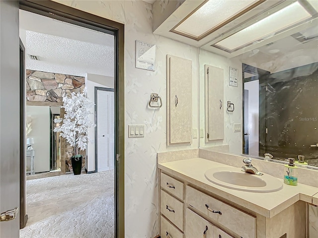 bathroom with a textured ceiling and vanity