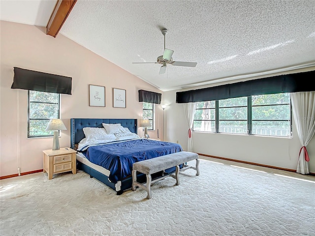 bedroom with ceiling fan, a textured ceiling, carpet floors, and lofted ceiling with beams