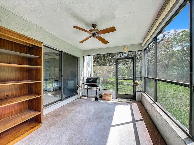 unfurnished sunroom featuring ceiling fan