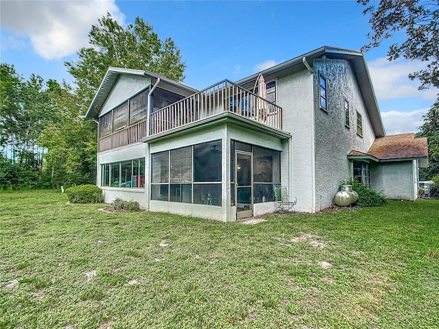 rear view of property with a yard and a sunroom