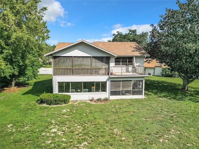 rear view of house featuring a yard and a sunroom