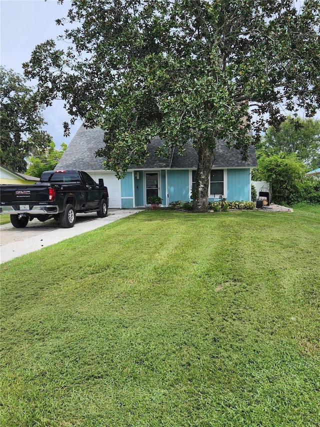 view of front of home with a garage and a front lawn